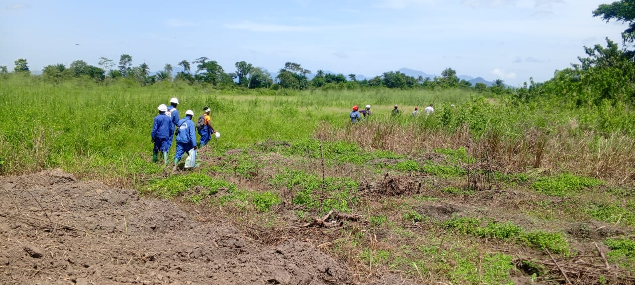 Étudiants en combinaison bleue et casque blanc lors d'une sortie de terrain en zone de bas-fonds.
