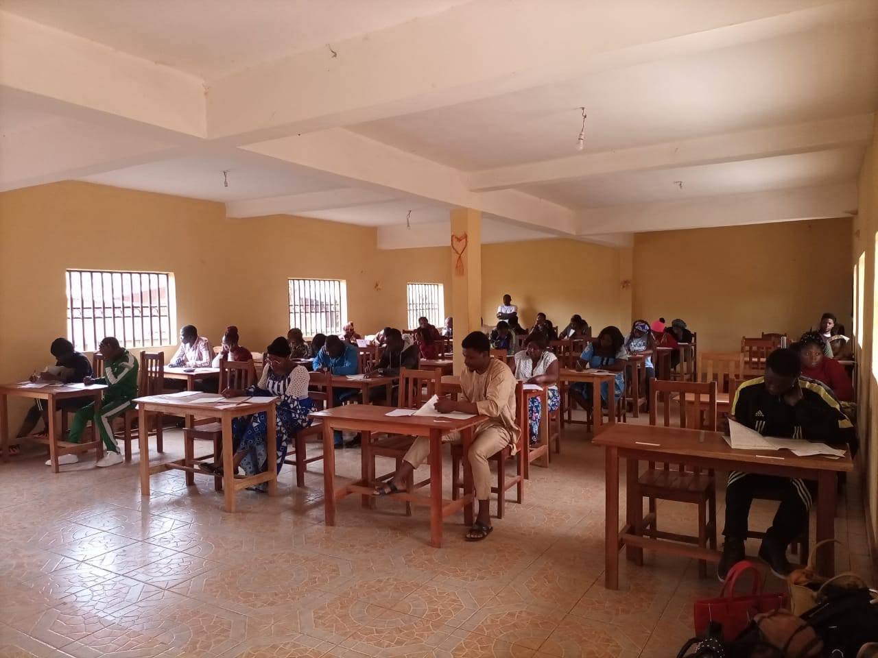 Étudiants de l'IESF en salle de composition, aux tables individuelles pendant une épreuve écrite.