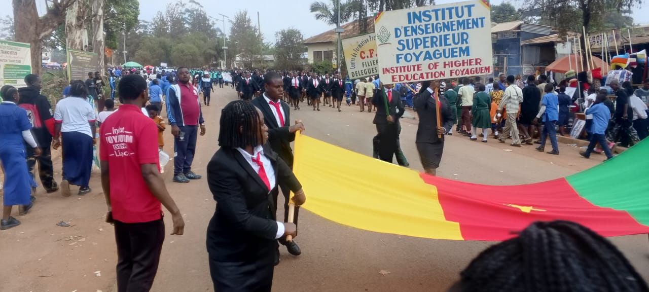 Défilé officiel, pancarte de l'Institut d'Enseignement Supérieur Foyaguem et drapeau national.