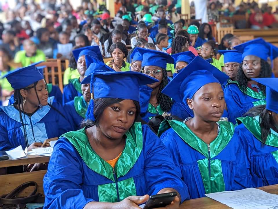 Diplômés de l'institut en toge bleue et verte lors de la proclamation des résultats.